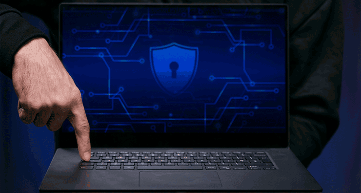 Uma pessoa segurando um laptop com um símbolo de segurança na tela