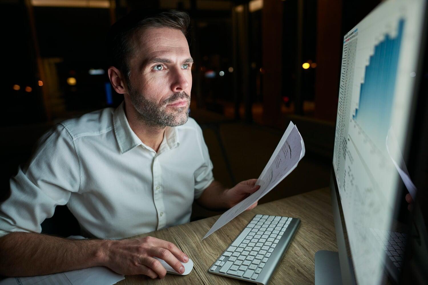 Homem pensativo em frente a tela de notebook