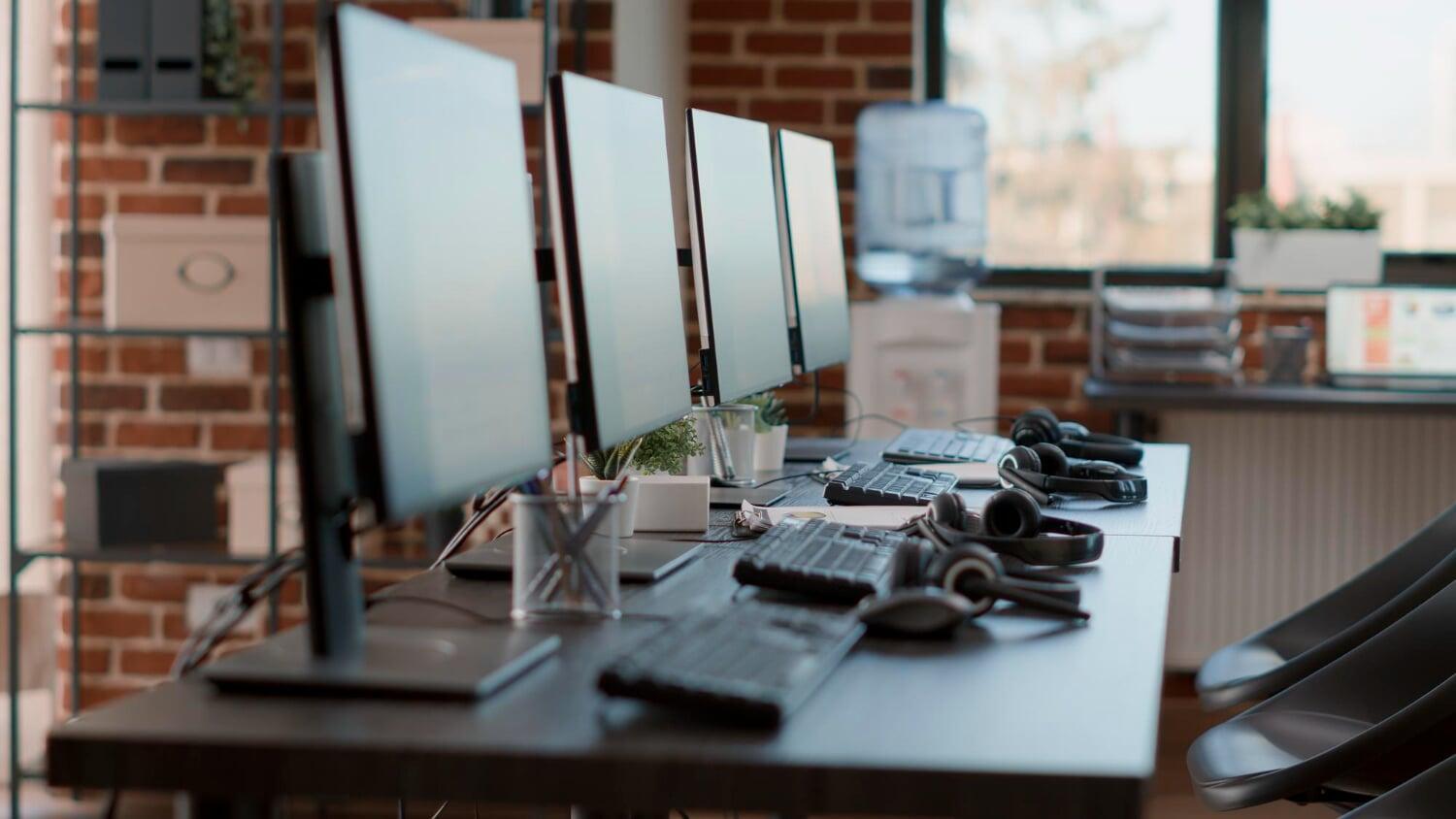 Estações de trabalho com monitores e headsets em um escritório moderno