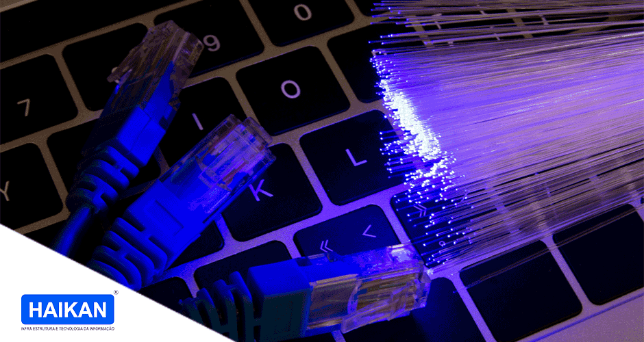 Foco em um teclado de notebook com alguns cabos de rede em cima